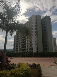 a large building with a palm tree in front of it at Maravilloso Apartamento Girardot Ricaurte con vista Panorámica in Ricaurte