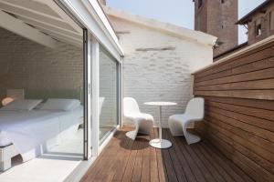 Un dormitorio con una cama y una mesa en el balcón. en Scaravelli Residenza en Mantova