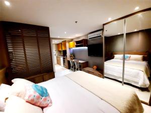 een hotelkamer met een bed en een televisie bij Estudio Itaipava - Granja Brasil - Flat Luxo 419 - Piscina Aquecida in Itaipava