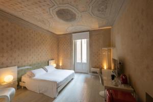 een slaapkamer met een wit bed en een schuin plafond bij Scaravelli Residenza in Mantova