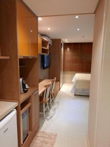 een slaapkamer met een bed, een bureau en een keuken bij Estudio Itaipava - Granja Brasil - Flat Luxo 419 - Piscina Aquecida in Itaipava