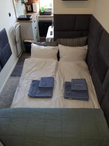 a bed with two blue towels on top of it at Mikro Apartament Solo na Starówce 8m2 in Kołobrzeg