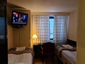 a hotel room with two beds and a flat screen tv at Hotelli Sandels in Siilinjärvi