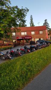 una fila de motocicletas estacionadas frente a un edificio en Hotelli Sandels, en Siilinjärvi