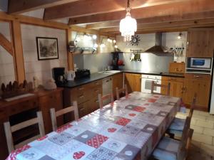 a kitchen with a table with a table cloth on it at Les Granges de la Fontaine in Antignac
