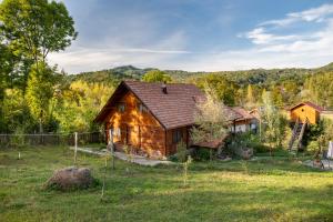 a wooden house in a field with a fence at La sat in Bertea