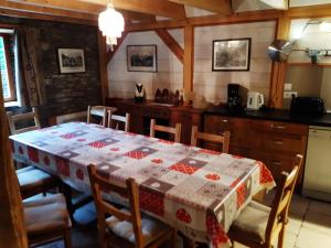 a kitchen with a table with a table cloth on it at Les Granges de la Fontaine in Antignac