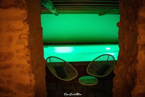 Léran的住宿－NATURE CATHARE，两把椅子放在窗户,享有绿色的光线