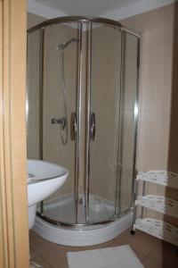 y baño con ducha y lavamanos. en Apartament za wydmą Sosnowa 13 en Mielno