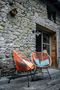 Léran的住宿－NATURE CATHARE，两把椅子坐在石头建筑前