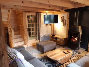 a living room with a couch and a fireplace at Les Granges de la Fontaine in Antignac