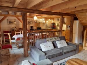 a living room with a couch and a kitchen at Les Granges de la Fontaine in Antignac