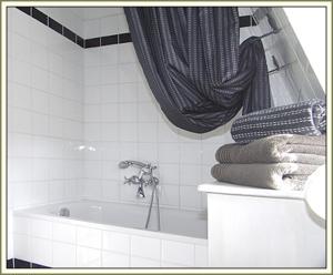 a bathroom with a tub with a shower curtain and towels at Gästehäuser Hölle 12 und Hölle 13 in Bamberg +43 photos