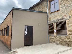 une porte de garage avec un panneau sur le côté du bâtiment dans l'établissement NATURE CATHARE, à Léran