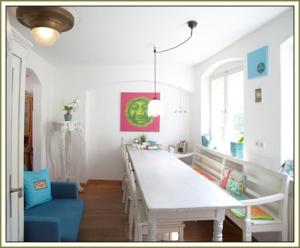 a dining room with a long table and a blue chair at Gästehäuser Hölle 12 und Hölle 13 in Bamberg