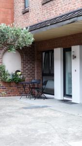 a table and chairs sitting outside of a brick building at Apartment "Lyon" in Korschenbroich