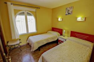 a hotel room with two beds and a window at Margarida - holiday bungalow in peaceful surroundings in Benitachell in Benitachell +24 photos