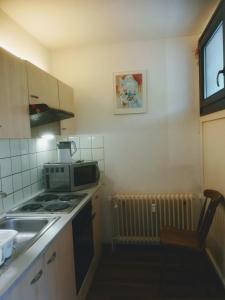 eine kleine Küche mit einem Herd und einer Mikrowelle in der Unterkunft Hannover Messe Wohnung 2 in Hannover