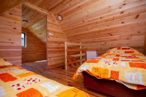 a bedroom with two beds in a log cabin at Brvnara Kovacevic in Zlatibor