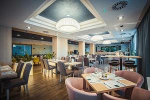 a restaurant with tables and chairs and a bar at Portofino Apartman in Sárvár
