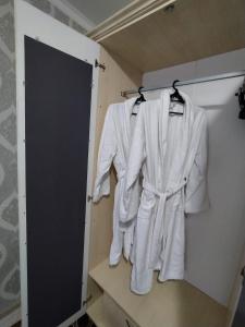 eine Gruppe weißer Roben, die an einer Wand hängen in der Unterkunft 2 комнатная в микрорайоне Шугыла in Qysylorda
