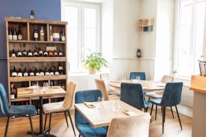 un restaurante con mesas, sillas y botellas de vino en L'Esplanade en Le Pellerin