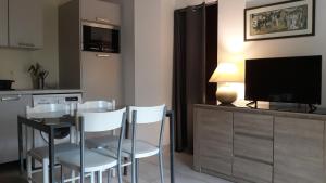 eine Küche mit einem Tisch und Stühlen sowie einem TV in der Unterkunft studio Eder Enea in Cambo-les-Bains