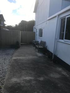 een patio met twee banken naast een gebouw bij Talland Studio in St Ives