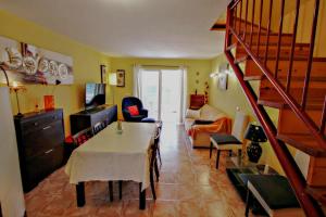 a living room with a table and a staircase at Margarida - holiday bungalow in peaceful surroundings in Benitachell in Benitachell