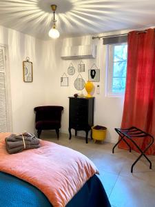 a bedroom with a bed with a red curtain and a window at Petit Rêve in LʼIsle-sur-la-Sorgue