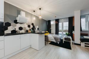 a kitchen and living room with a bed in the background at 4Eco Apart Charm Grzybowska City Center in Warsaw