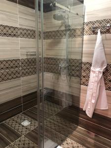 W łazience znajduje się szklana kabina prysznicowa i umywalka. w obiekcie Baitau Hotel Aktobe w mieście Aktobe