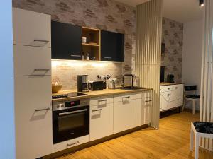 a kitchen with white cabinets and a stove top oven at Stadtgeflüster in Dessau