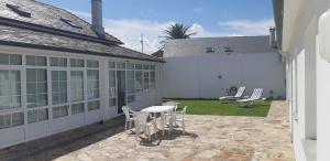 a patio with a table and chairs on the side of a house at Casa Sueño in Foz