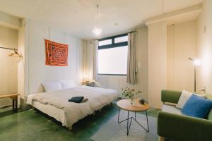 una camera con letto, tavolo e divano di Len Kyoto Kawaramachi a Kyoto