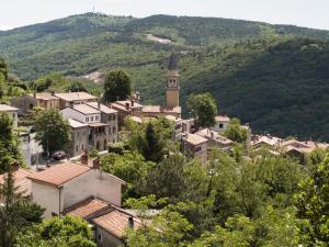 a town with a clock tower in the mountains at Il Glicine in San Dorligo della Valle