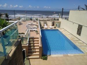 una piscina en la parte superior de un edificio junto a la playa en Pousada Elegance Beira Mar, en Itanhaém