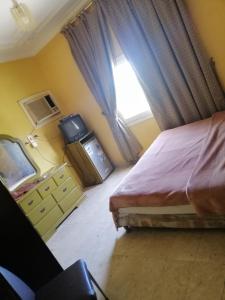 a bedroom with a bed and a window at Khobar Fantastic Furnished Apartments in Al Khobar