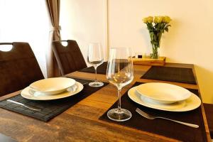una mesa de madera con platos y copas de vino. en Rivulet 2 bedroom Apartment en Baden-Baden