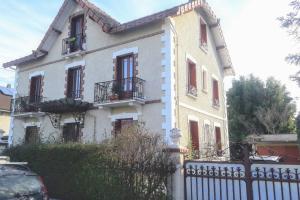 een groot wit huis met ramen en een hek bij T2 proche du lac in Aix-les-Bains