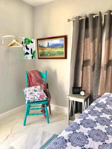 a bedroom with a blue chair next to a bed at Colorful and Luminous Suite near MIA - 4G in Miami