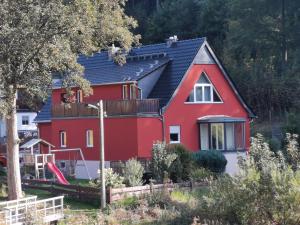 uma casa vermelha com um telhado preto em Wiesenblick em Dönschten