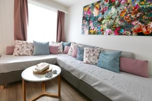 a living room with a couch with a painting on the wall at ALP APARTMENTS centre location with traditional design and self check-in in Engelberg