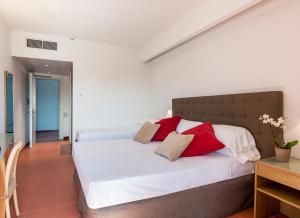 a bedroom with a large bed with red and white pillows at Rada Siri in Montepaone