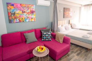 salon z różową kanapą i łóżkiem w obiekcie Ermou Downtown Studios by Hospitality Box w Atenach