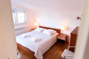 a bedroom with a bed with two white pillows at Apartment and Rooms Santini in Sveti Filip i Jakov