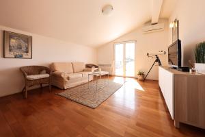 a living room with a couch and a table at Apartment and Rooms Santini in Sveti Filip i Jakov