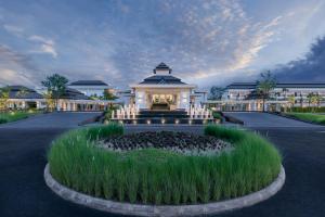 清莱Chainarai Riverside - SHA Plus Certified的公路中间有喷泉的建筑物
