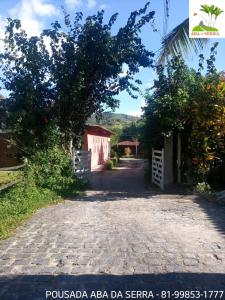 a road leading to a house with a tree at Pousada Aba da Serra in São Joaquim do Monte