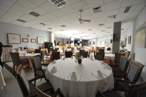 a dining room with a white table and chairs at Puerta de Segovia in La Lastrilla